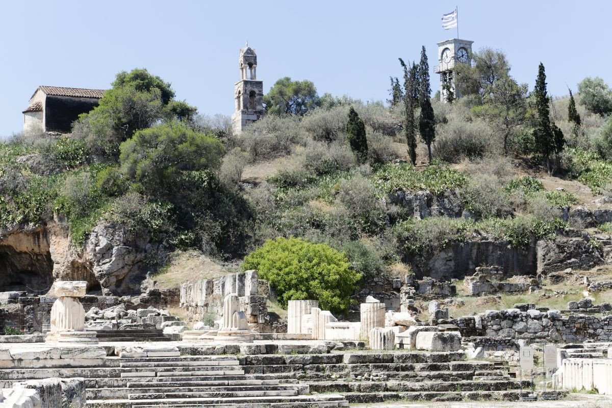 Ancient ruins in Elefsina, Greece, with a bell tower and a clock tower in the background.